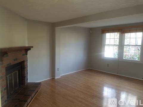 A living room with a fireplace and wood flooring.