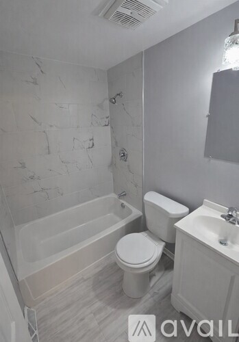 A bathroom with a toilet, sink, and bathtub.
