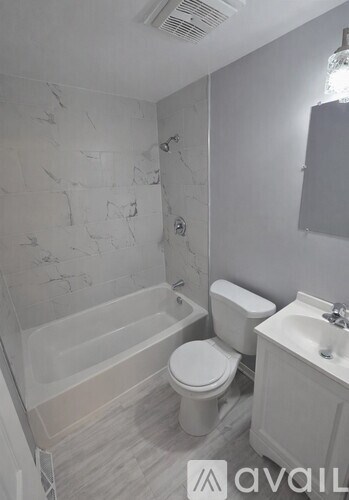 A bathroom with a toilet, sink, and bathtub.