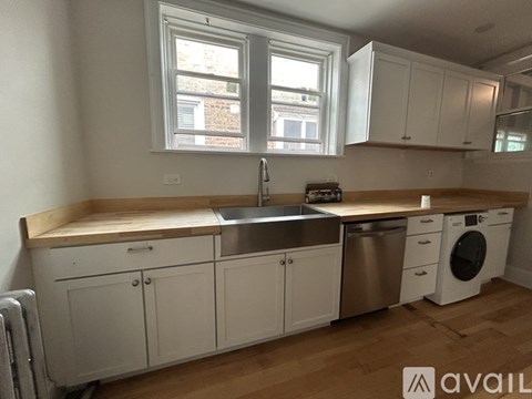 A kitchen with white cabinets and a wooden countertop.