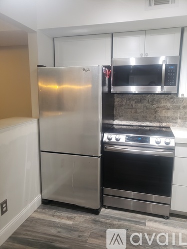 A kitchen with a stainless steel refrigerator, oven, and microwave.