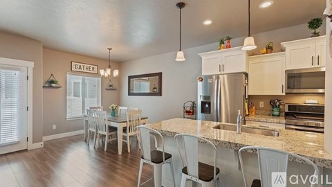 A kitchen with a dining table and chairs.