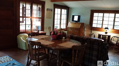 A dining room with a wooden table and chairs.