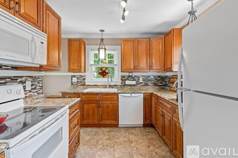 A kitchen with wooden cabinets and a white refrigerator.