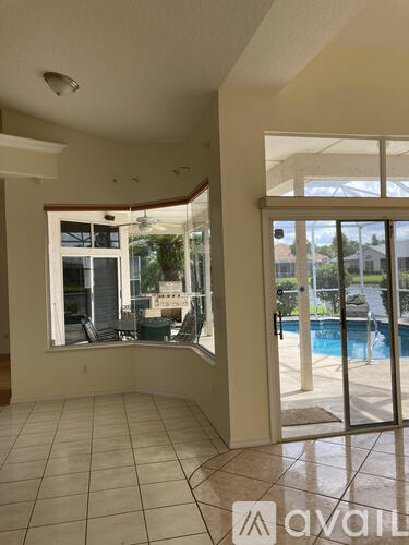 A room with a tiled floor and a view of a pool through a glass door.