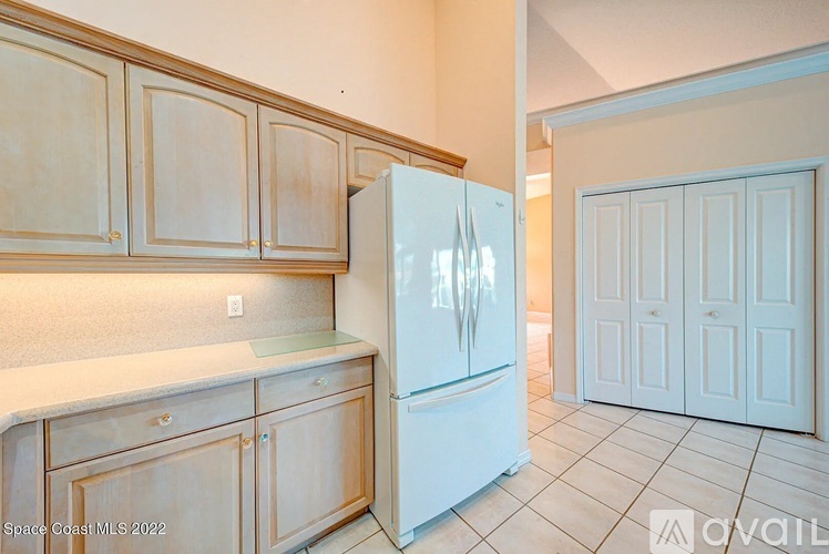 A kitchen with wooden cabinets and a white refrigerator.