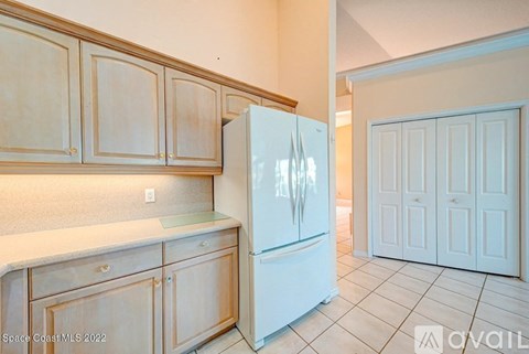 A kitchen with wooden cabinets and a white refrigerator.