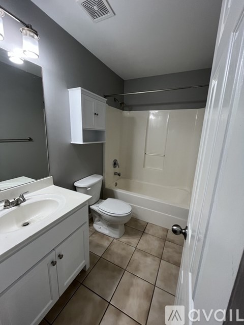 A bathroom with a toilet, sink, and mirror.