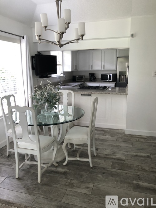 A dining room with a glass table and chairs.