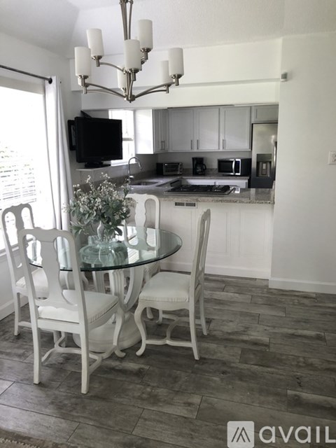 A dining room with a glass table and chairs.