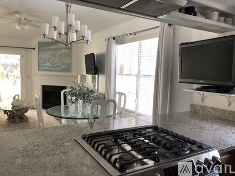 A modern kitchen with granite countertops and a stove top.