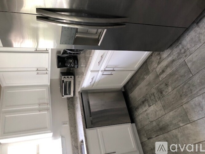 A kitchen with a stainless steel range hood and white cabinets.