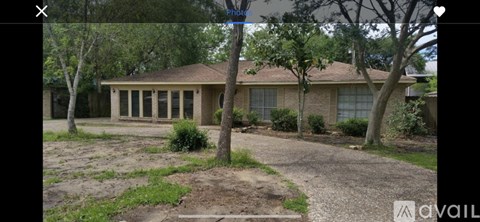 A house with a brown roof and a gravel driveway.