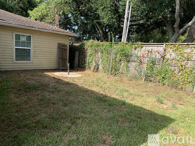 A backyard with a shed and a fence.