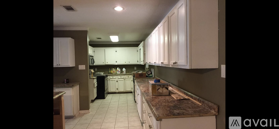 A kitchen with white cabinets and a granite countertop.