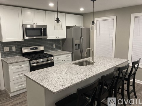 A kitchen with a granite countertop and stainless steel appliances.