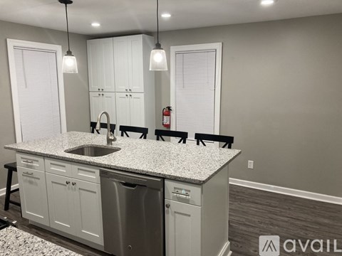 A kitchen with a granite countertop and white cabinets.