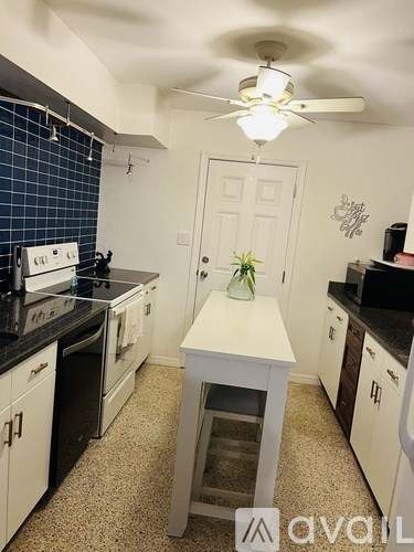 A kitchen with a white island in the middle.