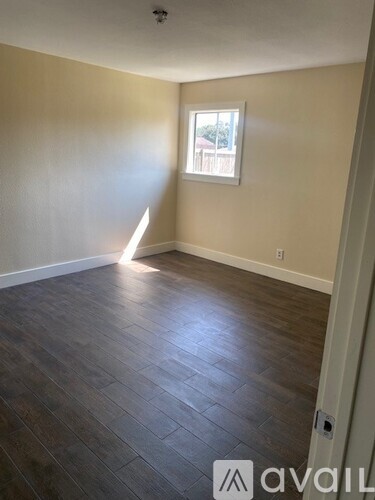 A room with wooden flooring and a window.