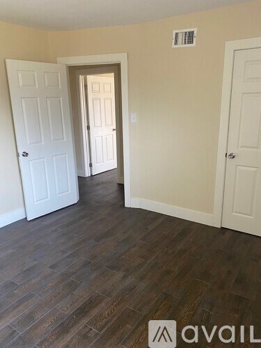 A room with wooden flooring and white doors.