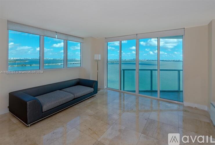 A living room with a large window overlooking the water.
