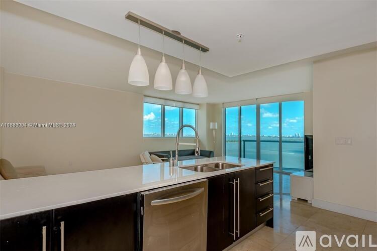 A modern kitchen with a large island and a view of the water.