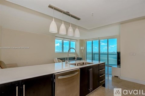 A modern kitchen with a large island and a view of the water.