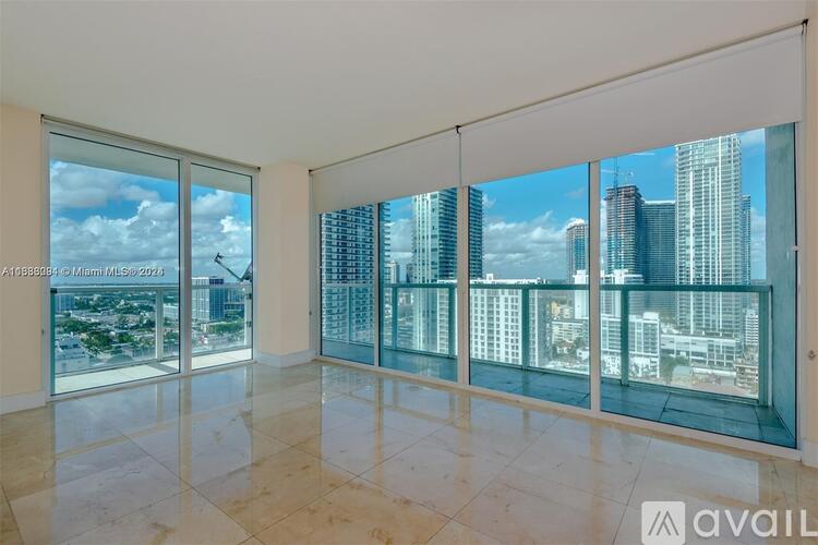 A spacious room with large windows overlooking a cityscape.