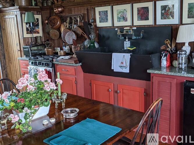 A kitchen with red cabinets and a wooden table.