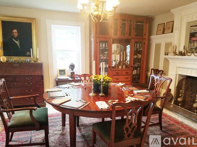 A dining room with a wooden table and chairs.