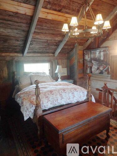 A bedroom with a bed and a chandelier.