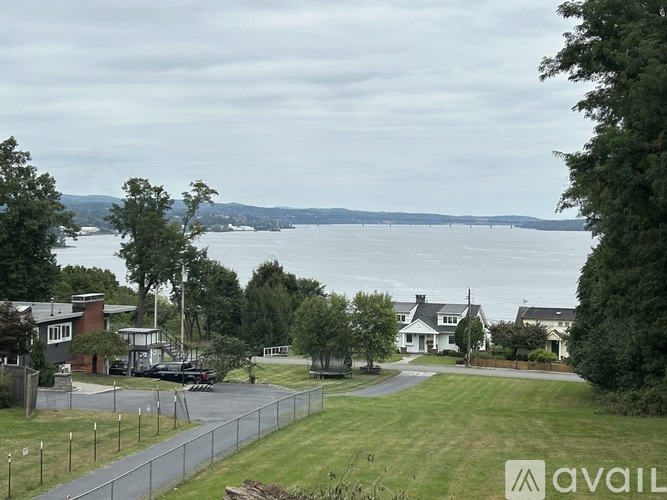 A view of a residential area with a body of water in the distance.