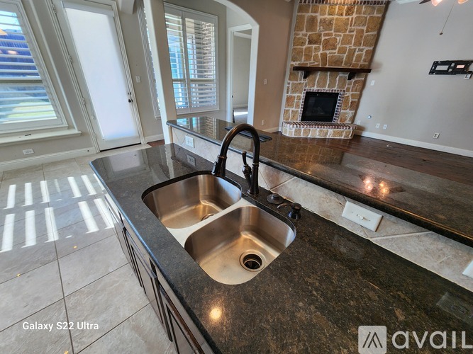 A kitchen with a sink and a fireplace.