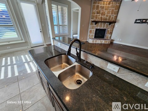A kitchen with a sink and a fireplace.