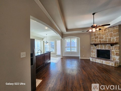 A living room with a fireplace and a ceiling fan.