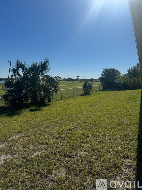 A sunny day with a clear blue sky and a green field.