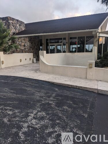 A building with a stone wall and a black roof.