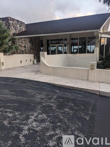 A building with a stone wall and a black roof.