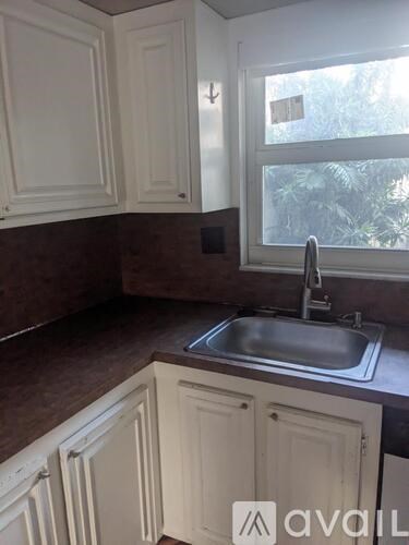 A kitchen with brown countertops and white cabinets.