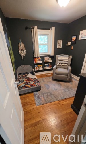 A living room with a grey chair and a rug.