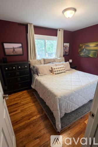 A bedroom with a large bed and a dresser.