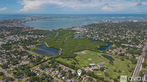 An aerial view of a residential area with a large body of water in the foreground.