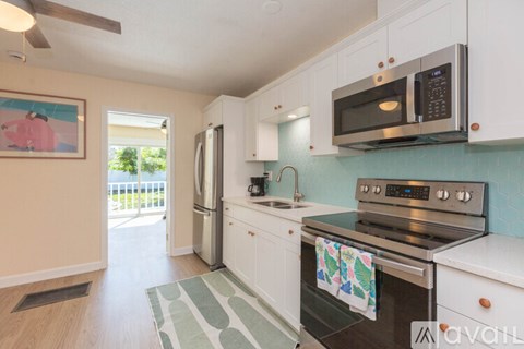 A kitchen with white cabinets and a black stove top.