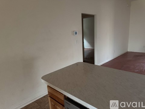 A room with a brown floor and a grey countertop.
