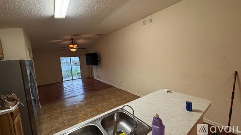 A kitchen with a sink and a refrigerator.
