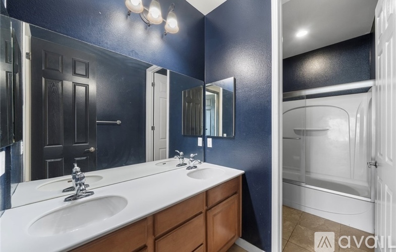 A bathroom with a white sink and a mirror above it.