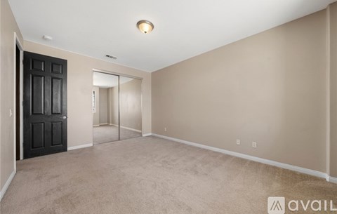 A room with a black door and carpeted floor.