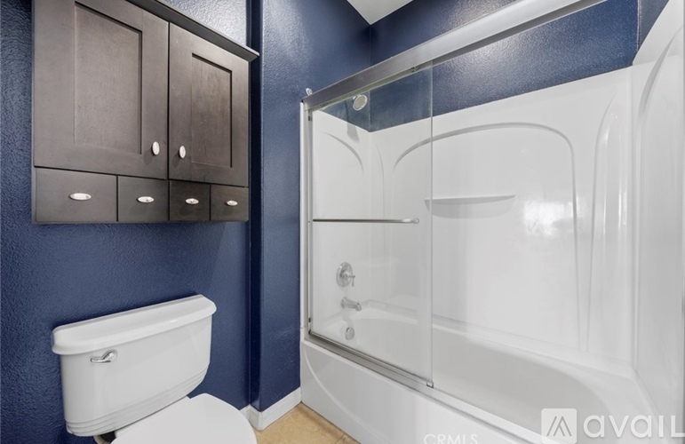 A white toilet sits next to a walk-in shower with a glass door.