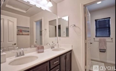A bathroom with two sinks and a large mirror.