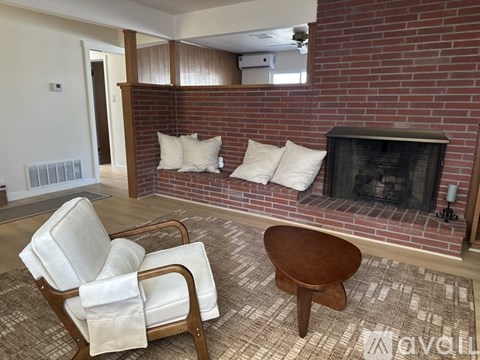 A living room with a fireplace and a chair.
